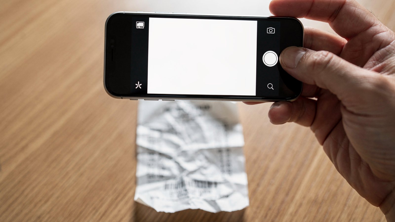 Unternehmer fotografiert einen Papierbeleg mit dem Smartphone, um ihn digital an die Buchhaltung zu übertragen (KI-generiertes Bild)