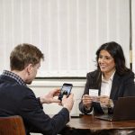 DATEV Unternehmen online: Belege, Bank, Kassenbuch und Auswertungen im Alltag – Steuerberaterin Fatma Tabak-Özkul erklärt einem Unternehmer am Laptop die Arbeit mit DATEV Unternehmen online (KI-generiertes Bild)