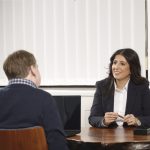 PHP2Shell-Schaden steuerlich absetzen: Notfall-Update, Forensik, neue Website – Fatma Tabak-Özkul bespricht mit einem Unternehmer seine Unterlagen am Besprechungstisch der Kanzlei